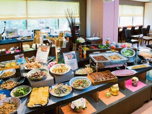 Un buffet proposant une variété de plats et une pancarte avec du texte en japonais.