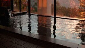 An indoor swimming pool with a view of a sunset over a mountainous landscape. - Hotel North Shiga (Yamanouchi)