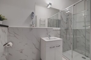 Habitación triple | Baño | Regadera, amenidades de baño ecológicas, secadora de cabello, pantuflas 