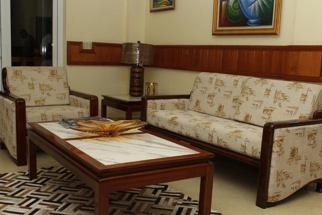Ein Wohnzimmer mit gestreiften Sofas, einem Holztisch und einem gemusterten Teppich.