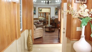 A hallway leading to a living room with a sofa, coffee table, and decorative vases.