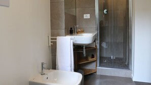 A modern bathroom with a toilet, bidet, and shower. - Re Ruggero Rooms (Reggio Calabria)