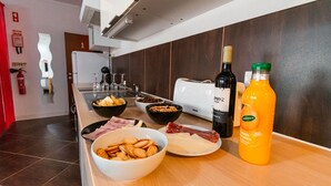Een aanrecht met verschillende soorten eten, een fles sinaasappelsap en een fles wijn.