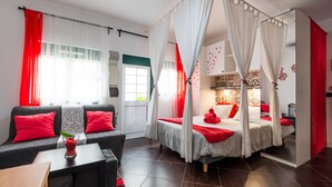 Een moderne hotelkamer met een bed, een bank en een klein tafeltje.