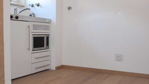 A kitchen with a built-in oven, a microwave, and a sink.