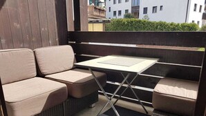 A balcony with a sofa set and a table.