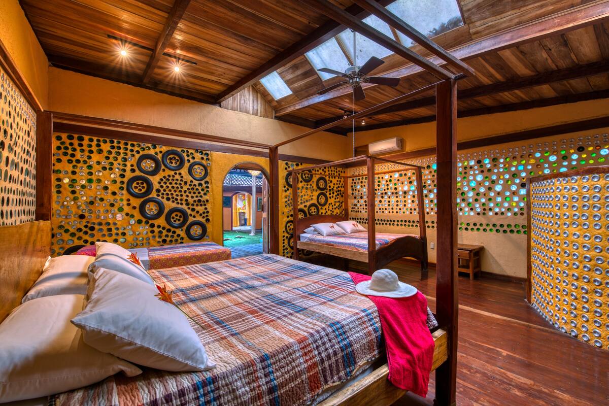 Een kamer met een hemelbed, een plafondventilator en een dakvenster.