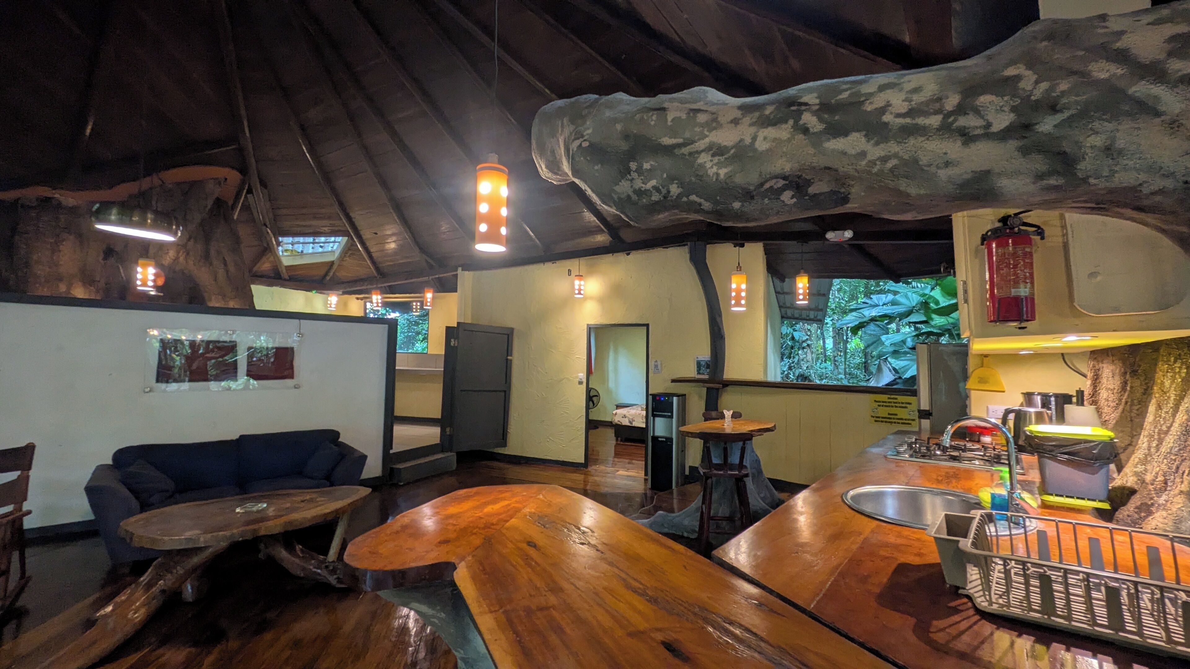 A rustic interior with wooden furniture, a bar area, and a view of the outdoors.