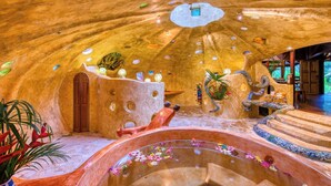 Ein luxuriöses Interieur mit einer zentralen Wasserspiele, Steinwänden und einer gemütlichen Sitzecke.