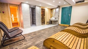 A spa room with wooden benches, a sauna, and a massage area. - Riverside Jasna (Demanovska Dolina)
