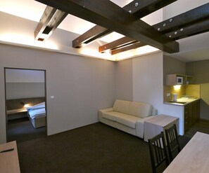 Suíte luxo, 2 quartos, sacada | Área de estar | TV de tela plana 32 polegadas com canais via satélite, TV