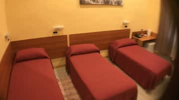 Two single beds with wooden headboards and matching bedspreads, a table, and a chair.