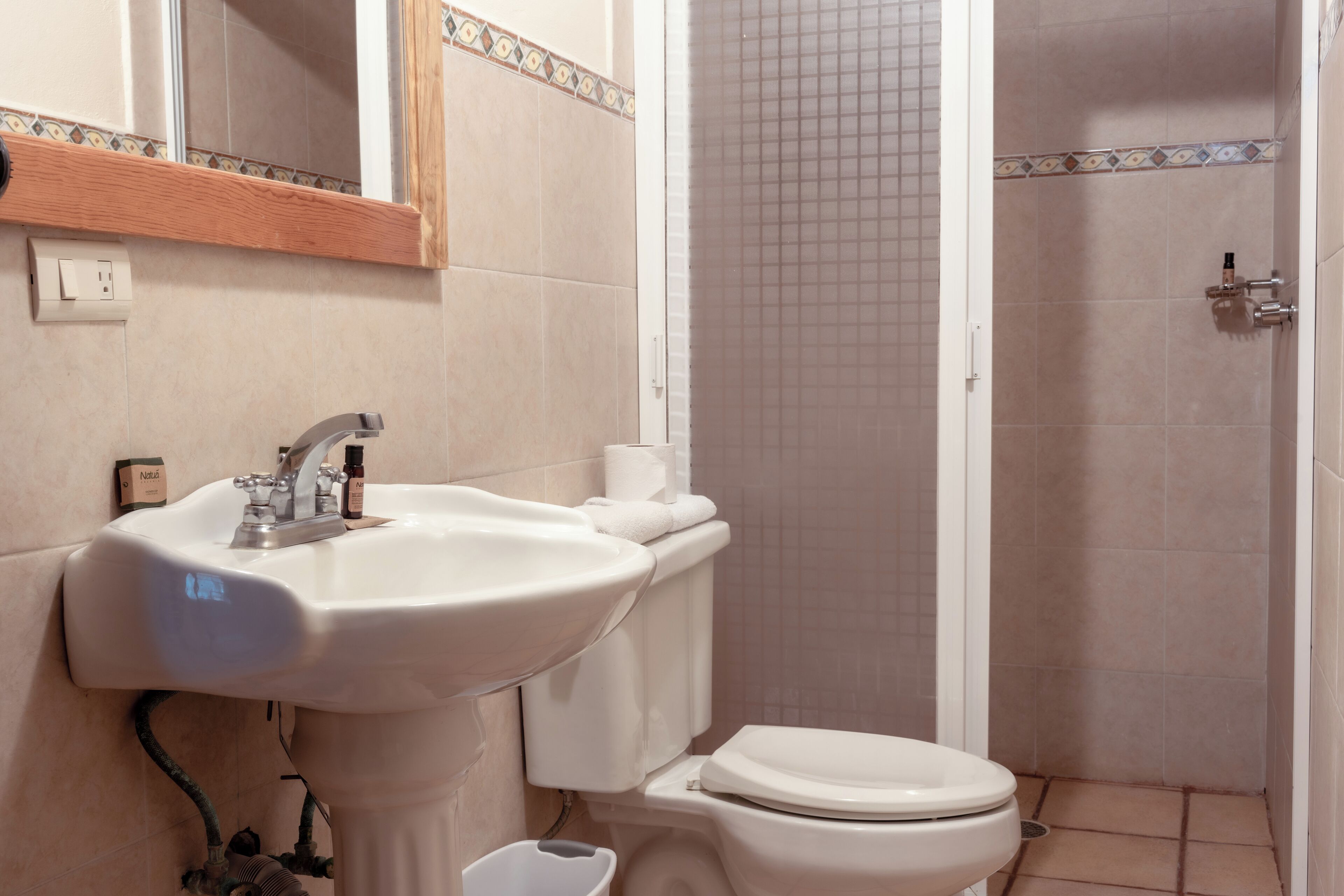 Une salle de bain équipée d’un lavabo, de toilettes et d’une zone douche.