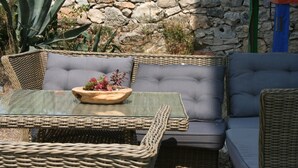 A wicker outdoor seating area with a glass table and cushioned chairs. - Luxury villa with private heated pool and sea view 2 (Marina)