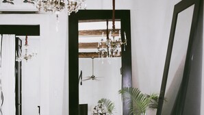 A room with a large bathtub, a chair, a table, a chandelier, and a mirror. - Coqui Coqui Valladolid (Valladolid)