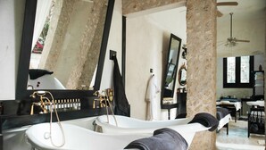 A bathroom with a bathtub, a large mirror, and a ceiling fan. - Coqui Coqui Valladolid (Valladolid)