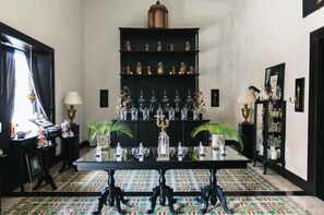 A room with a black table, patterned floor, and shelves with glassware. - Coqui Coqui Valladolid (Valladolid)