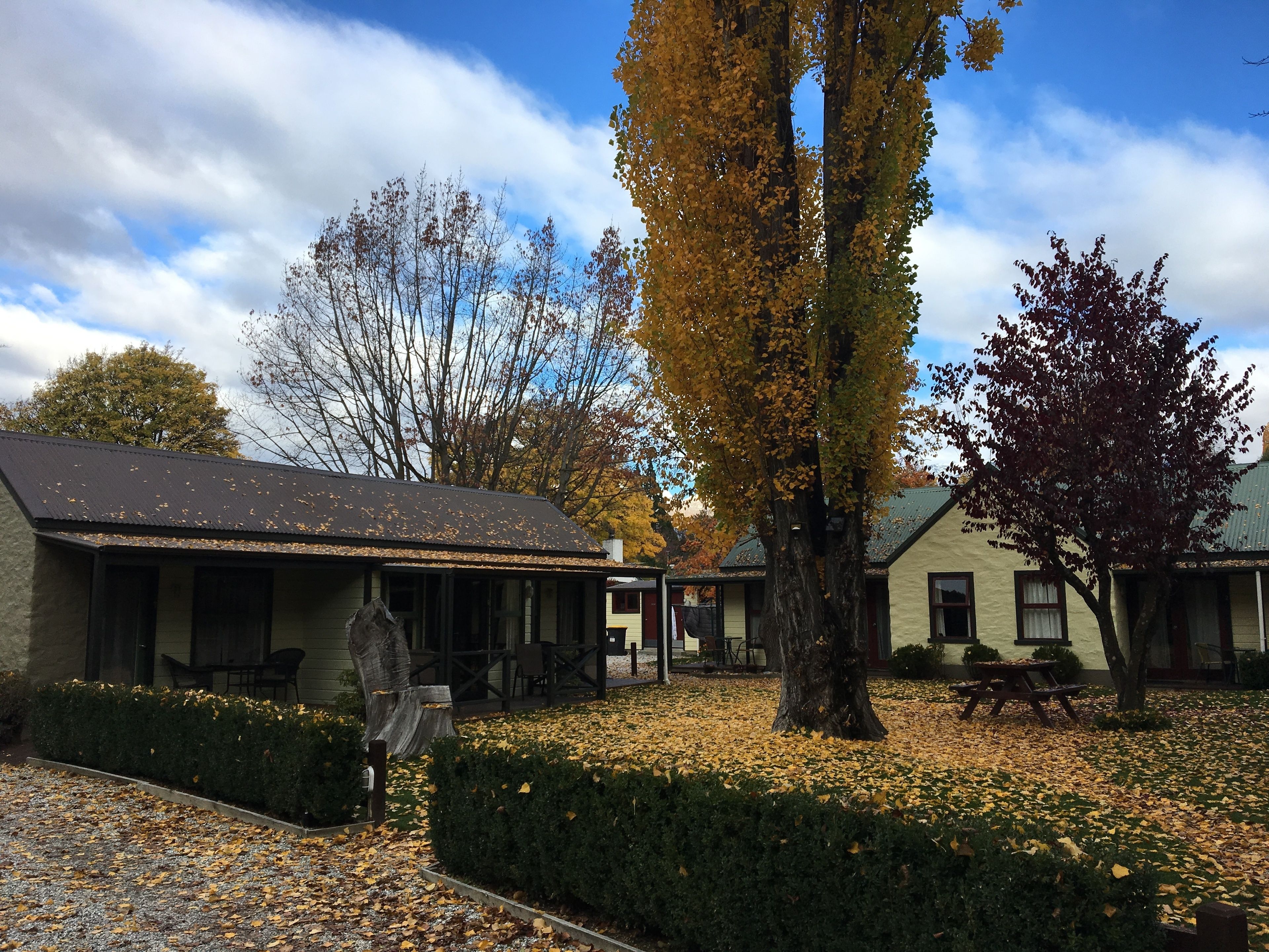 A building with a covered porch and a picnic table.
