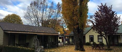 A building with a covered porch and a picnic table.