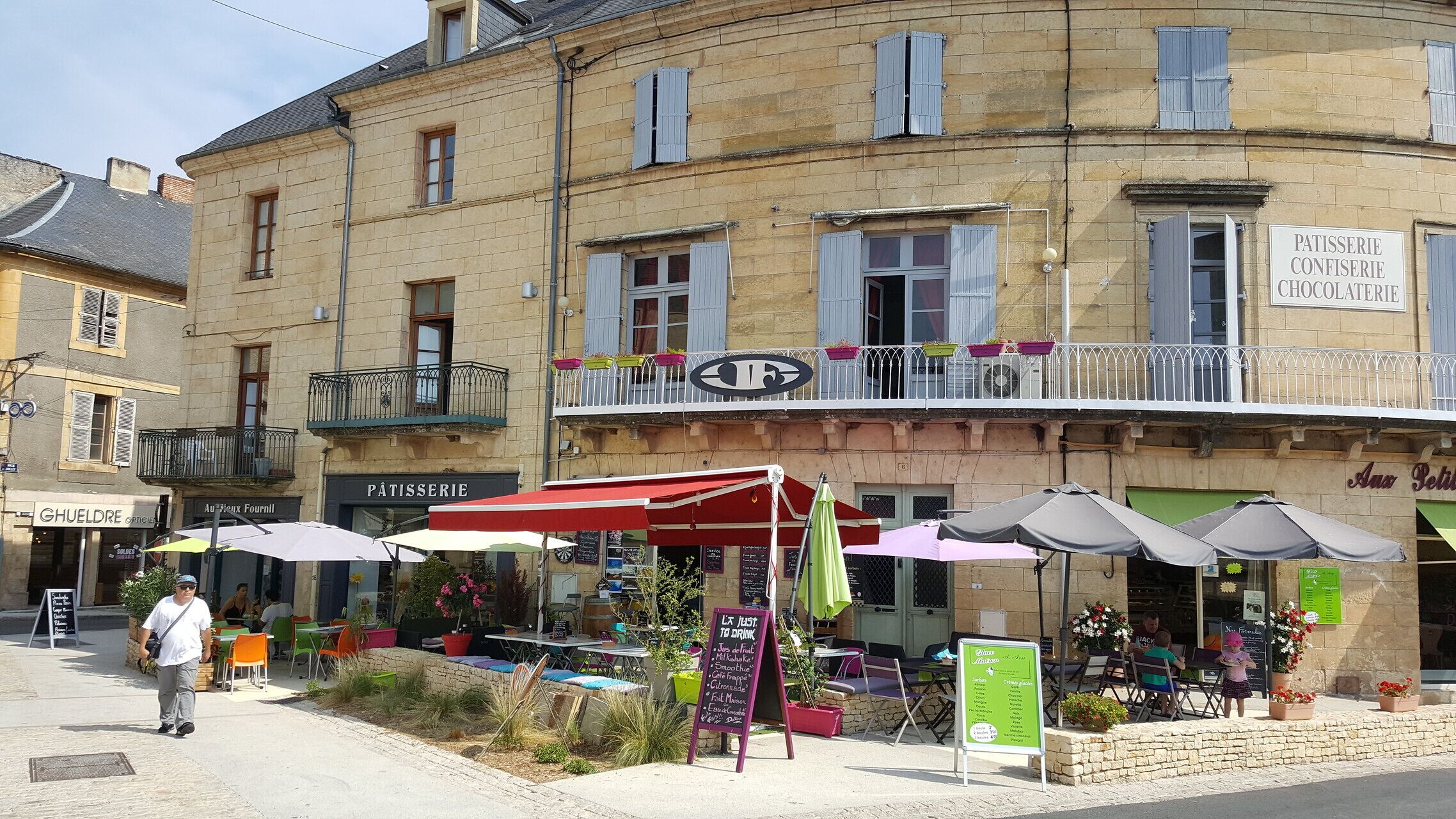 A café with outdoor seating and a sign for a patisserie confiserie.