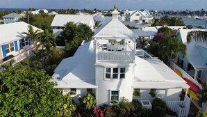 A white building with a balcony and a view of the sea.