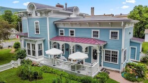 A large, two-story house with a porch and multiple windows.