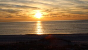 A sunset over a calm sea with a beach in the foreground. - North end of Cape Gulf Front 1 level w/elevator from carport & screened-in porch (Cape San Blas)