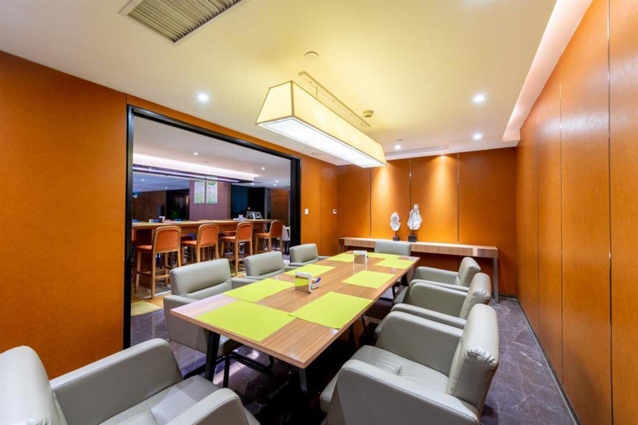 A conference room with a long table, chairs, and a modern ceiling light fixture.