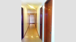 A long, narrow hallway with wooden doors on both sides, leading to rooms. - Bakasyunan Inn Laoag (Laoag)