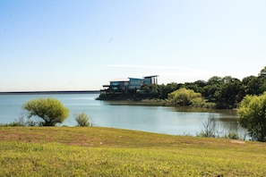 A lakeside property with a modern house featuring a large deck and a view of the lake. - Walking distance to the Gaylord and backs to Lake Grapevine! (Grapevine)