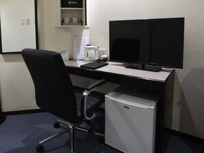 A hotel room with a desk, a black office chair, a white mini-fridge, a black TV, a coffee maker, and a sign indicating free WiFi. - RHotels Inn Hokkaido Asahikawa (Asahikawa)