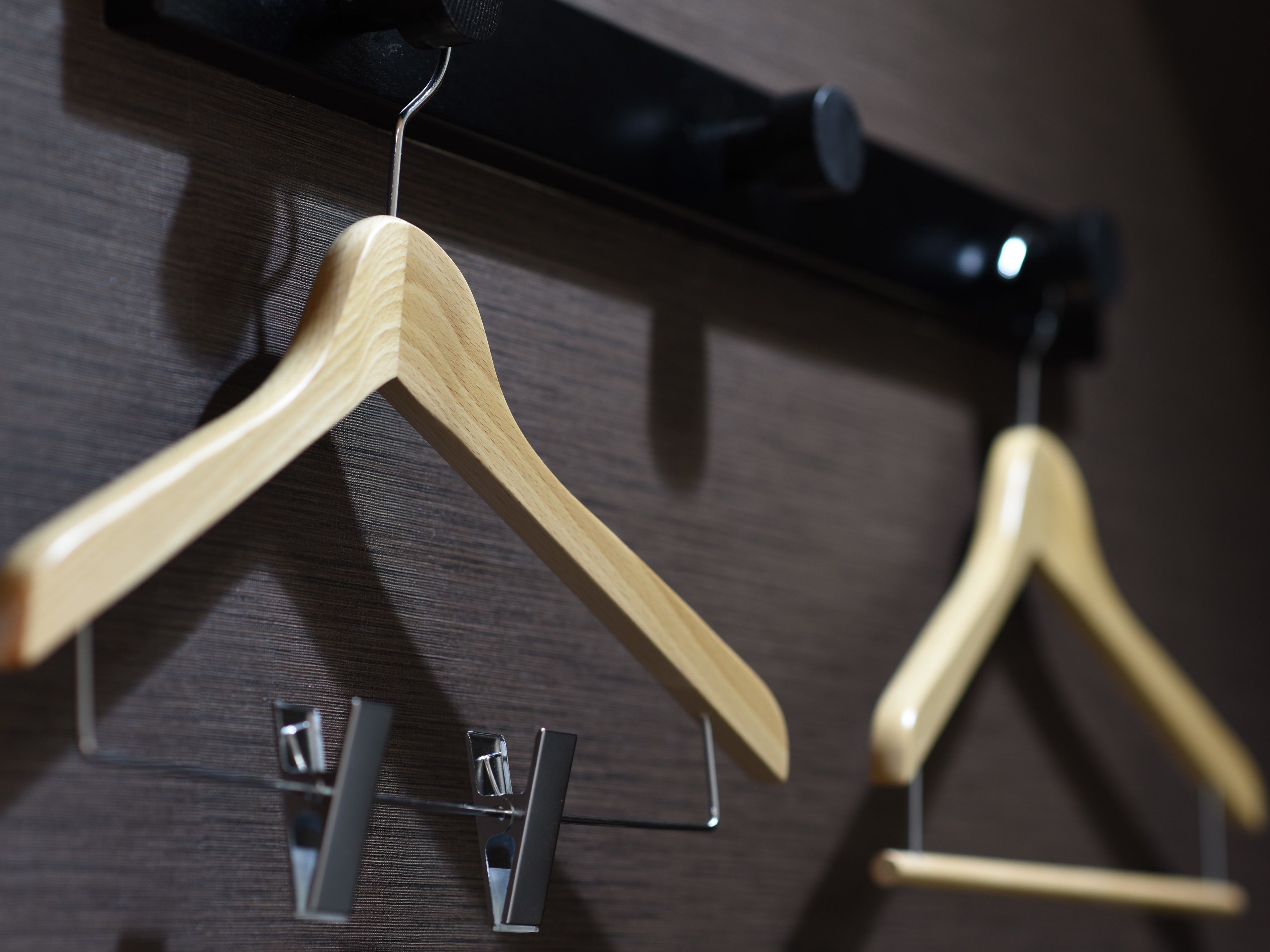 Houten hangers op een wandbevestigd rek.