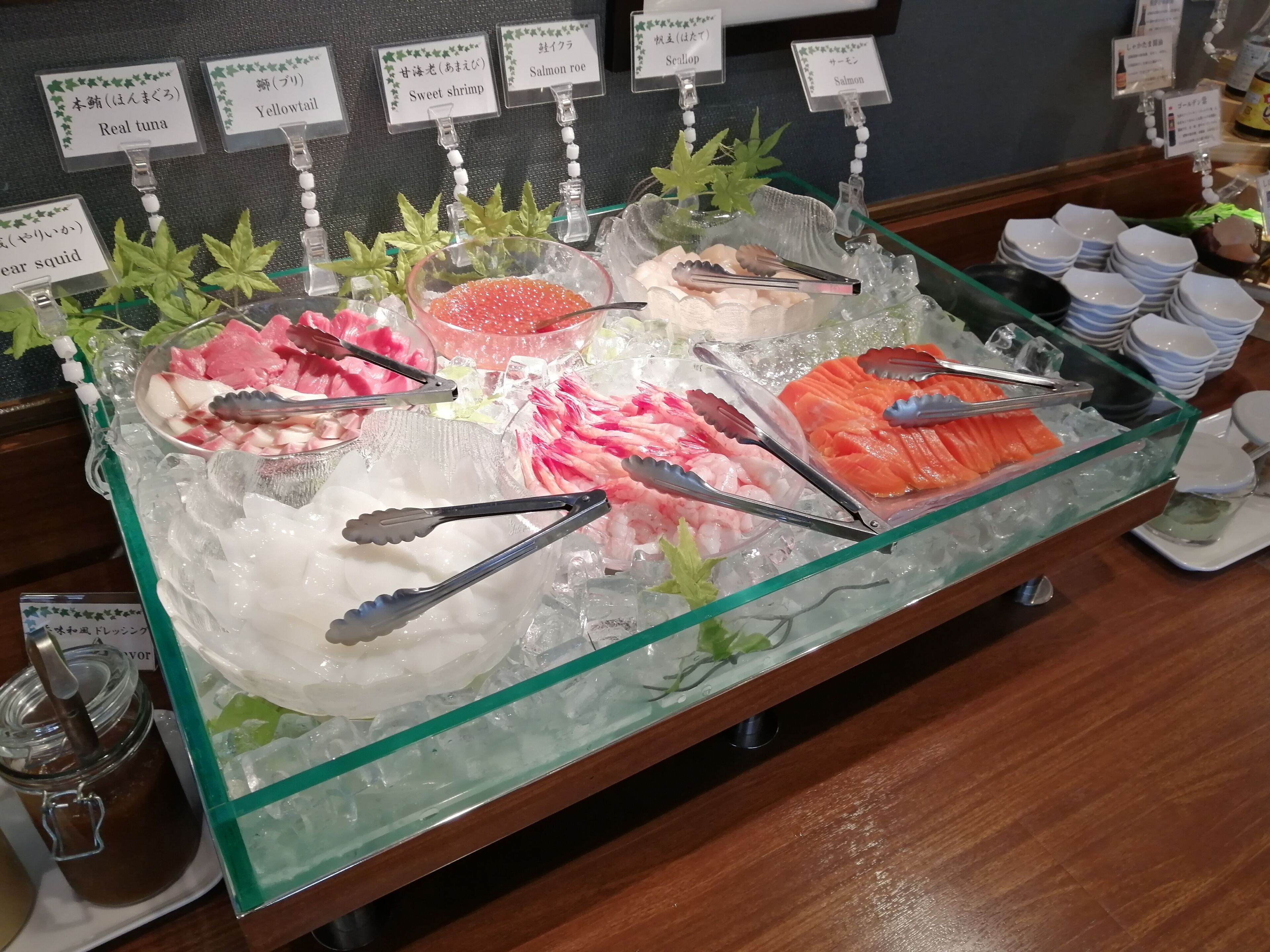 A seafood display with various types of fish and seafood, including salmon roe and scallop, on ice.