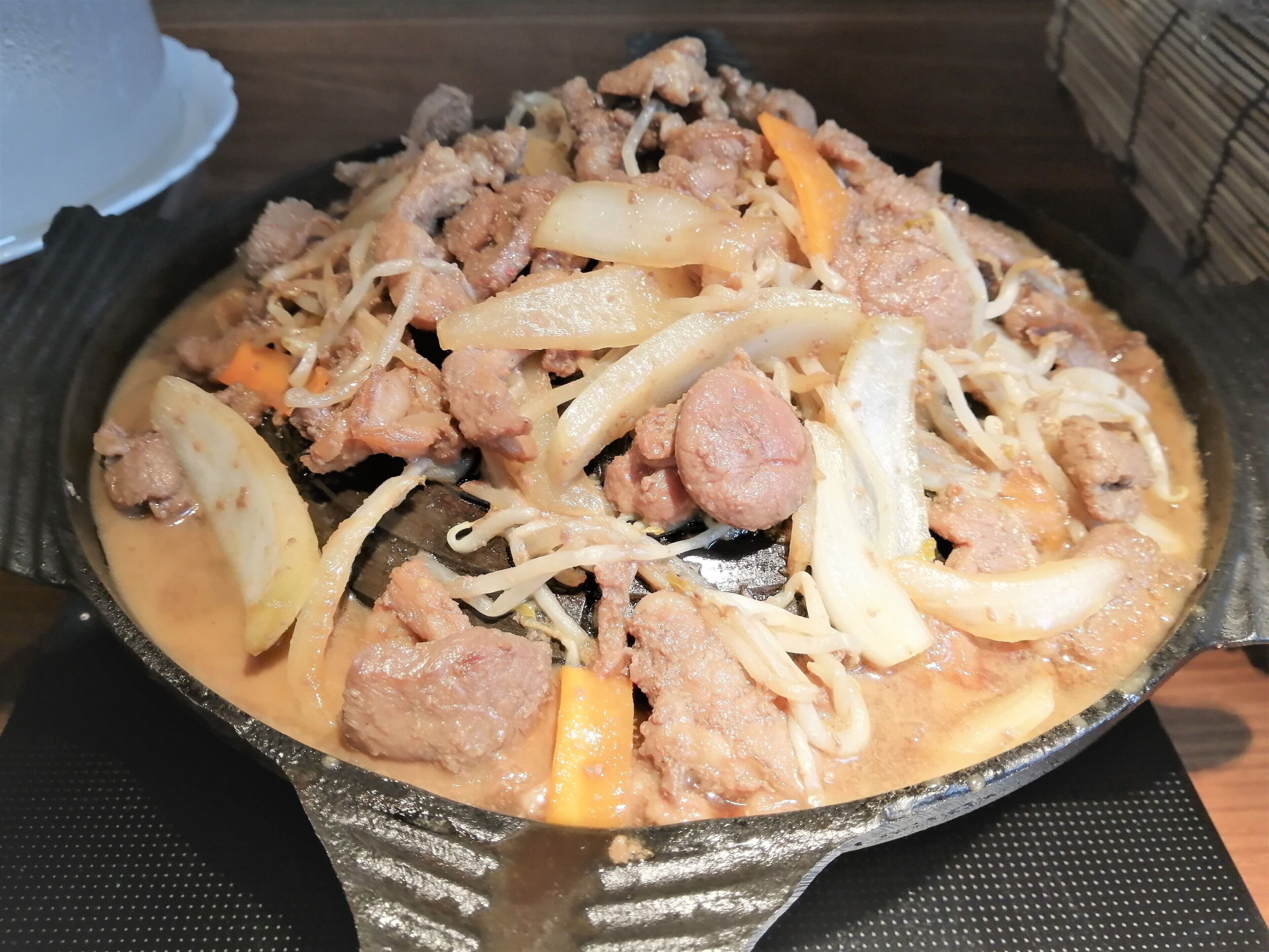 Uma frigideira com um ensopado contendo pedaços de carne e legumes.
