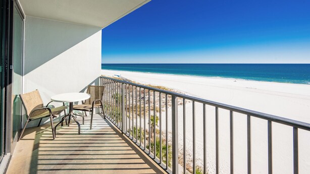 A balcony with a view of a beach and ocean.