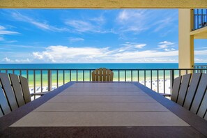 Een balkon met uitzicht op een strand en de oceaan.