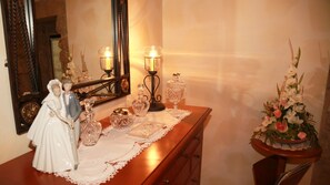 A wooden dresser with a mirror, decorative glassware, and a figurine. - Casa Do Sear (Sanxenxo)