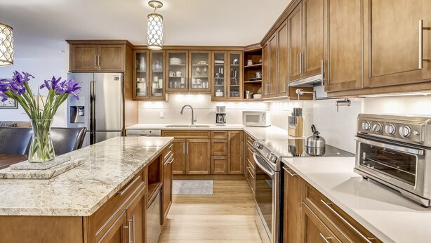 A modern kitchen with wooden cabinets, stainless steel appliances, and a marble countertop. - Ute Condominiums - Central & Cozy (Aspen)