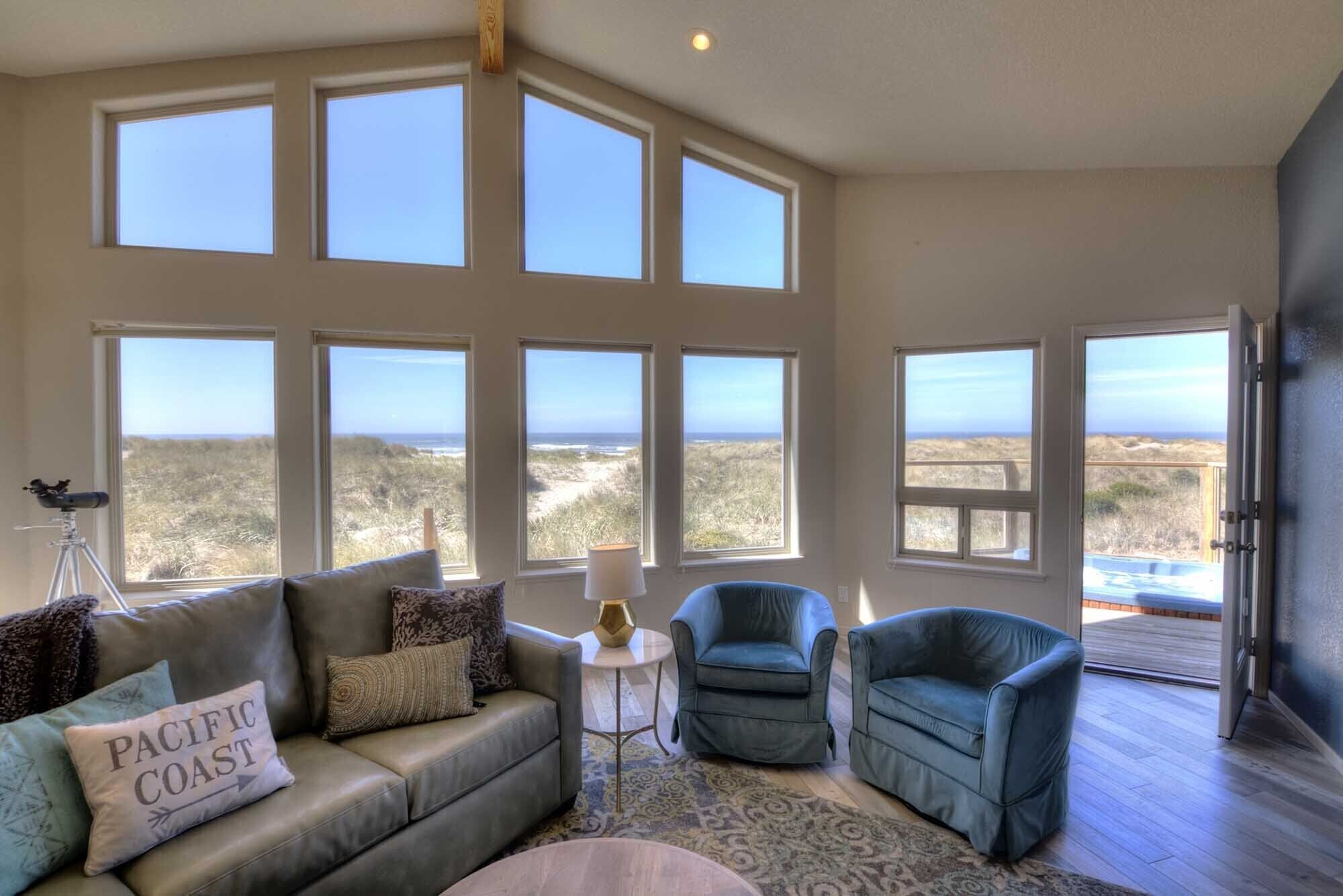 A spacious living room with multiple large windows offering views of the beach and dunes. - Oceanfront on Sandy Beach! Hot Tub! Dog Friendly! Direct Beach Access! Game Room! (Waldport)