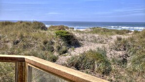 A coastal landscape with dunes, vegetation, and the ocean. - Oceanfront on Sandy Beach! Hot Tub! Dog Friendly! Direct Beach Access! Game Room! (Waldport)