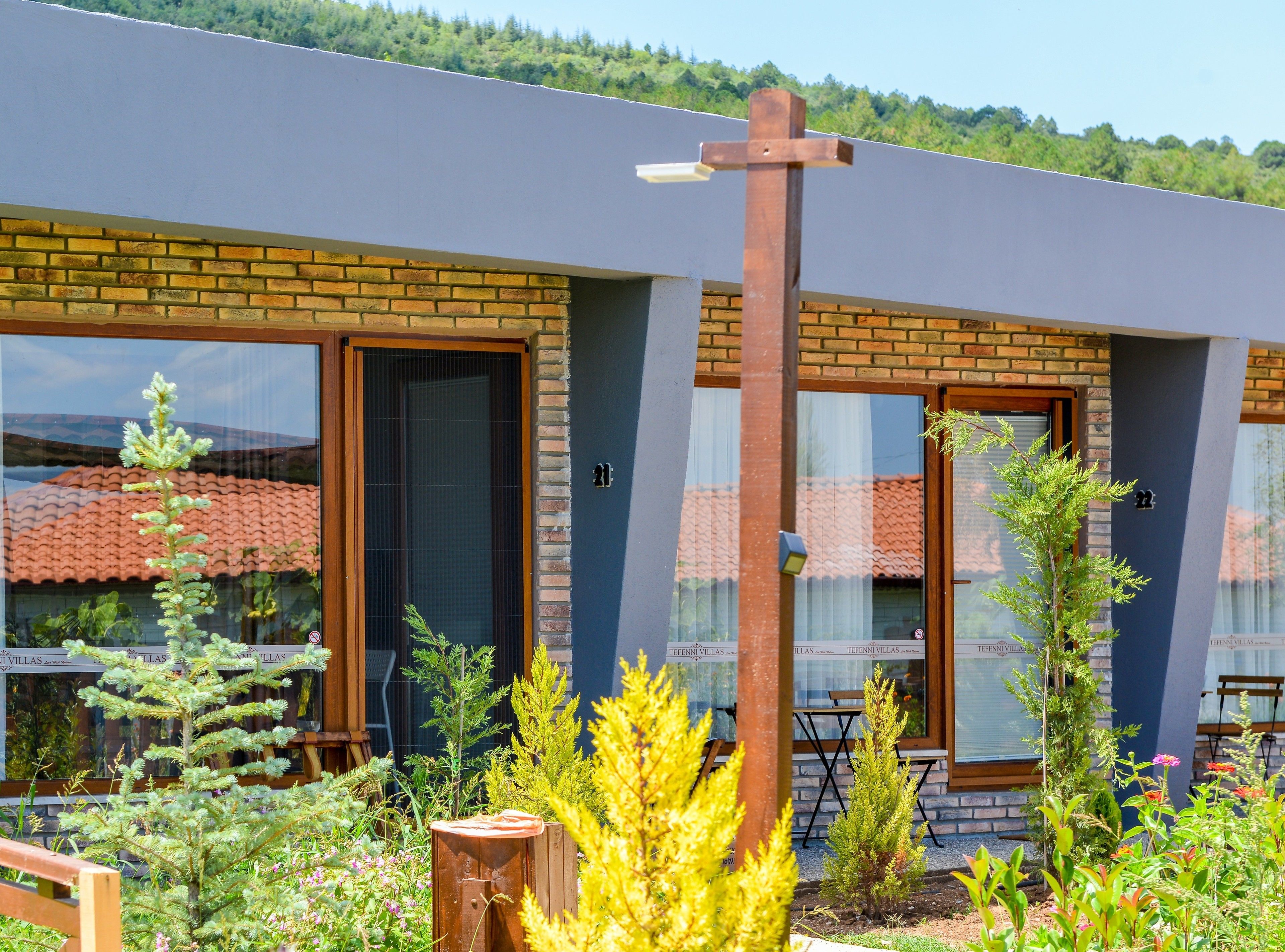 A modern building with large windows, a brick facade, and a wooden cross.