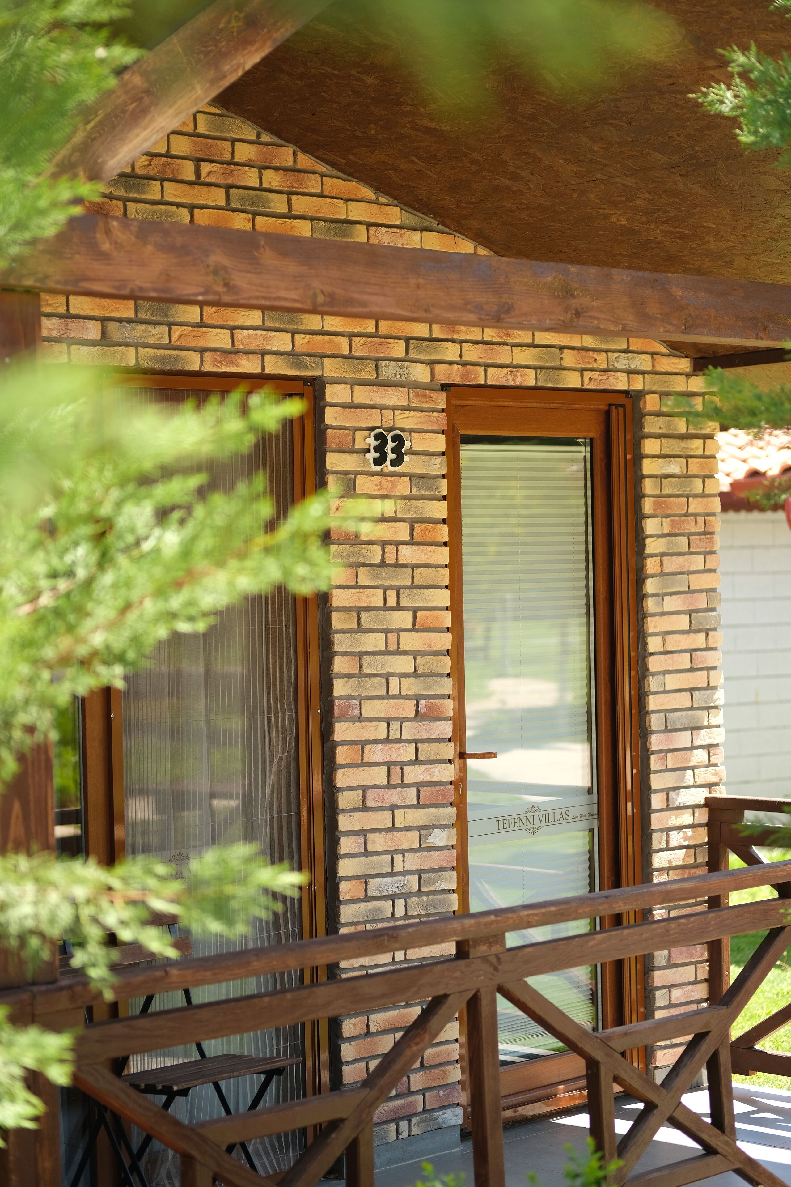 Un bâtiment en briques portant le numéro 33, avec un porche en bois et une porte dotée d’une fenêtre.