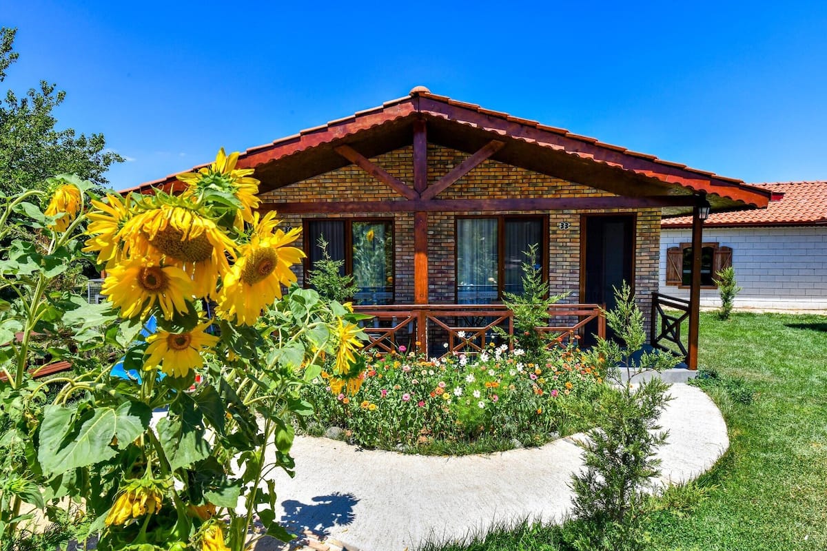A rustic building with a wooden porch and brick walls.