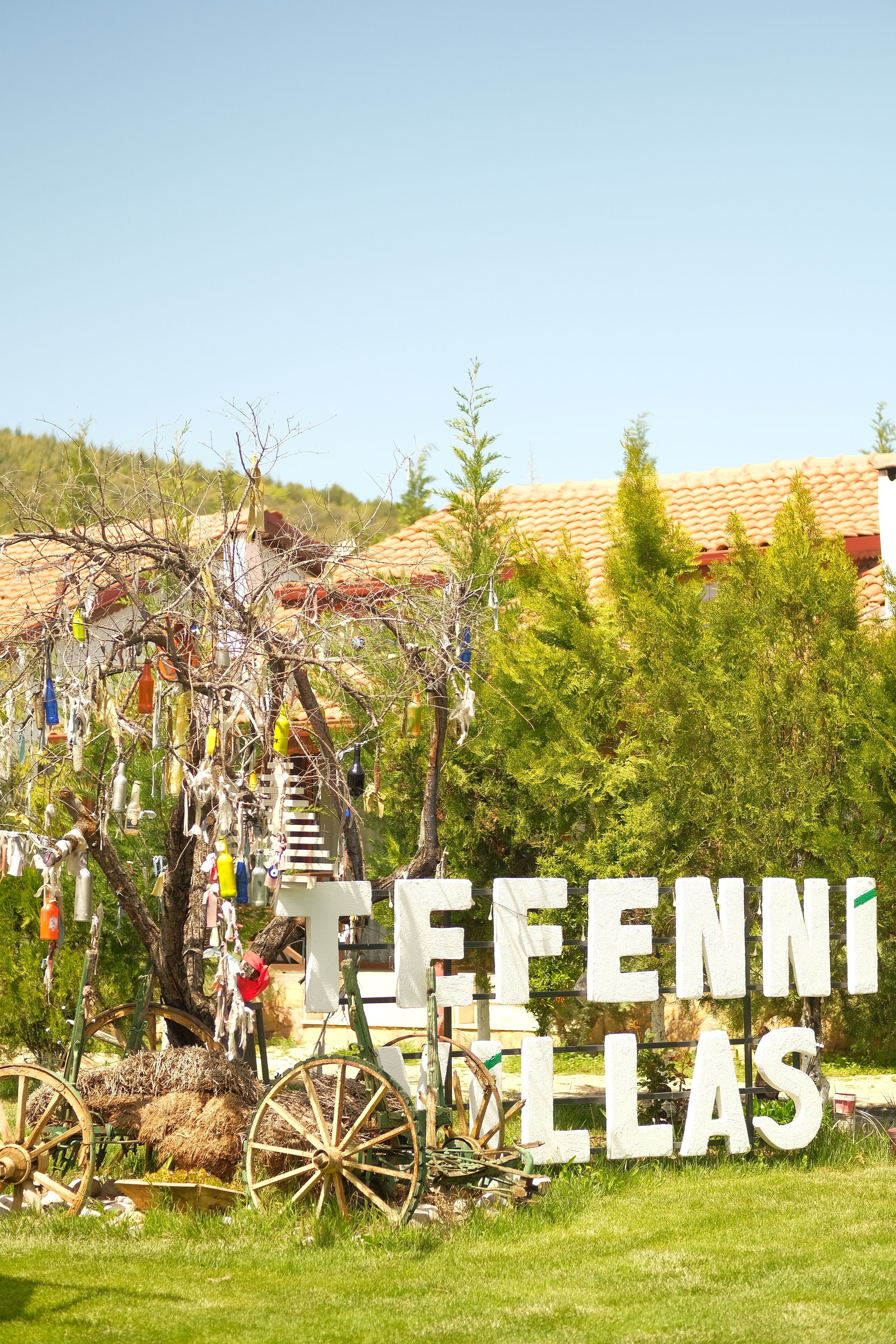 A rural setting with a sign reading "FENNELLAS" and a rustic cart.
