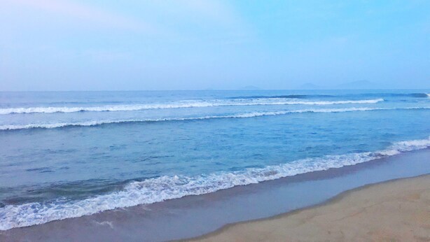 Una playa con olas acercándose a la orilla.