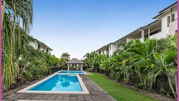 A pool area with two rectangular pools, surrounded by palm trees and a small gazebo. - Resort Style Apartment-3beds, 2bath, 3 Pools (West End)