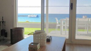 A room with a view of the sea, a wooden table with a kettle, a box, and a candle holder. - Millpond - Penneshaw Beach (Penneshaw)
