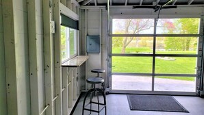 A room with a large window, a door, and a small stool. - Manistee Channel Waterfront Home with Boat Dock (Manistee)