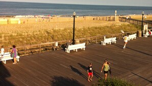 A boardwalk with benches and a view of the beach.
