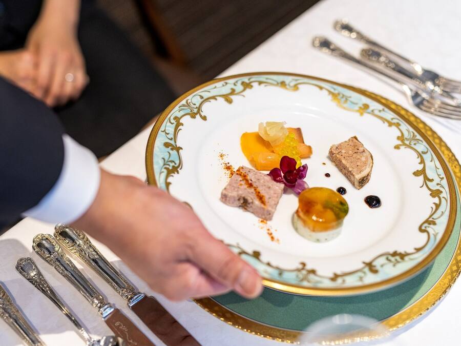 Una persona servint un plat amb diferents aliments.